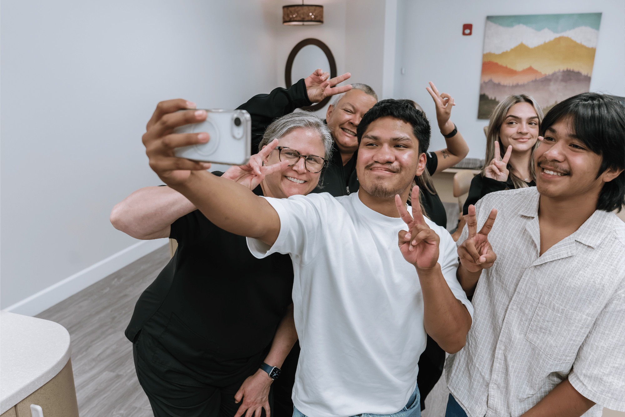 Group of smiling patients and staff at Marris Orthodontics taking a selfie, showcasing community and positive experiences in orthodontic care, emphasizing the practice's friendly atmosphere and commitment to patient satisfaction in Orlando.