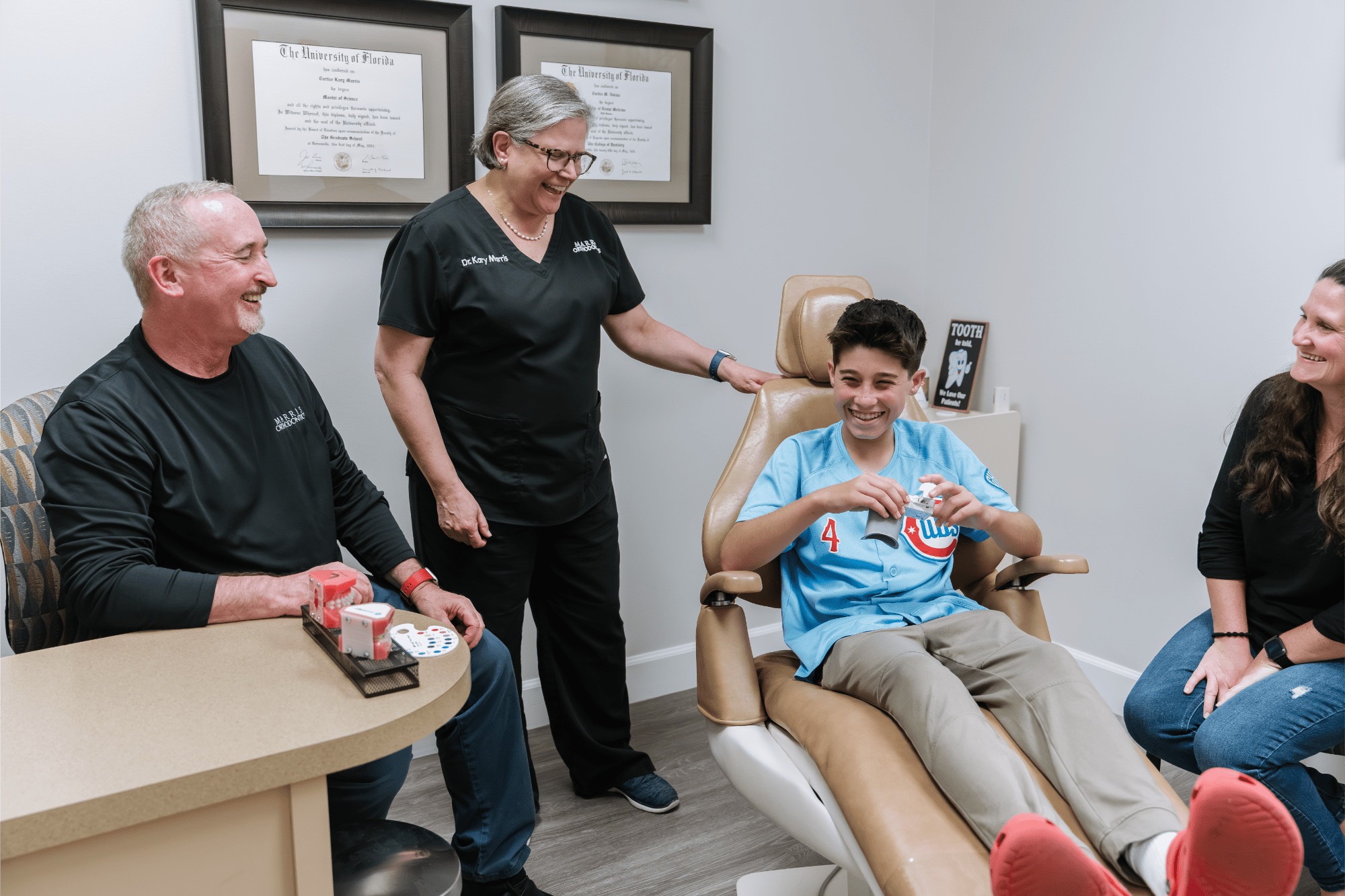 Dr. Kary Marris interacting with a young patient in an orthodontic office, showcasing a friendly environment for orthodontic care in Orlando, Florida, highlighting braces and Invisalign services.