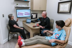 Patient consultation at Marris Orthodontics with Dr. Marris, discussing braces and Invisalign options in a welcoming office setting.