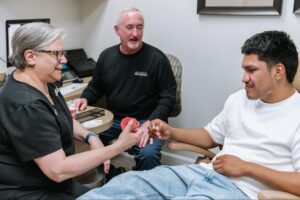 Patient consultation at Marris Orthodontics with staff member assisting, showcasing a welcoming orthodontic environment focused on braces and Invisalign in Orlando.