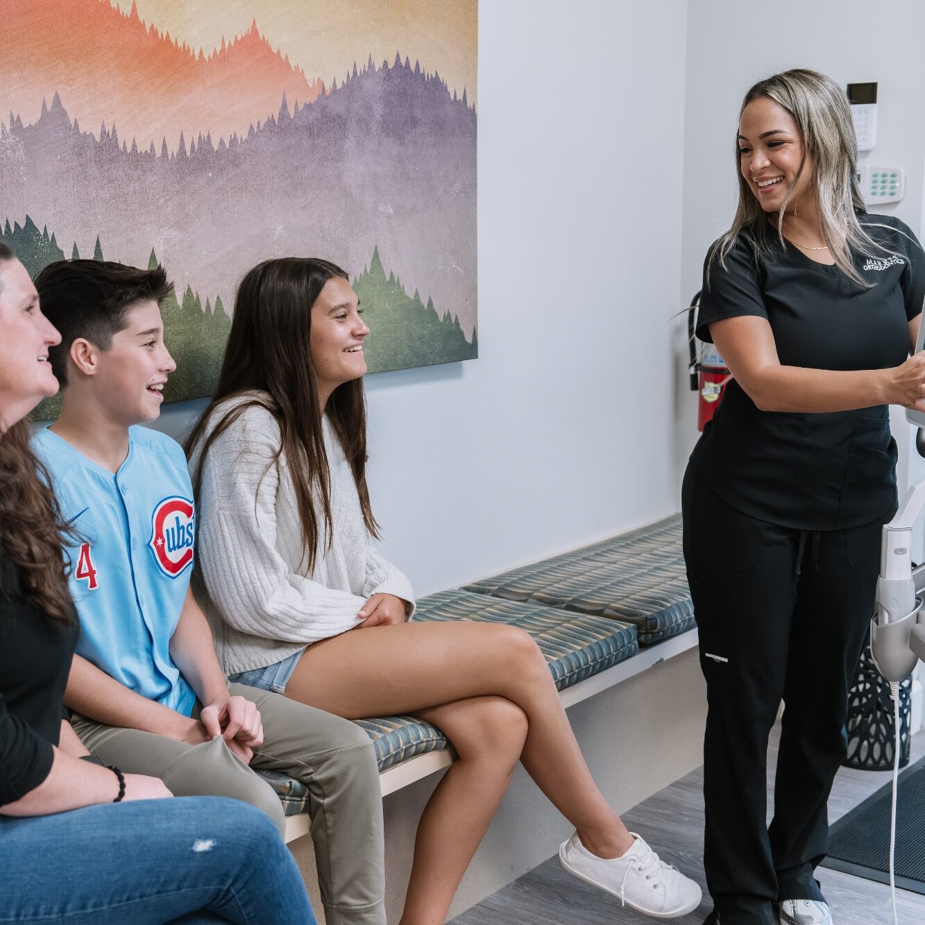 Smiling patients interacting with a dental professional in a modern orthodontic office, showcasing Marris Orthodontics' welcoming environment for braces and Invisalign consultations in Orlando.
