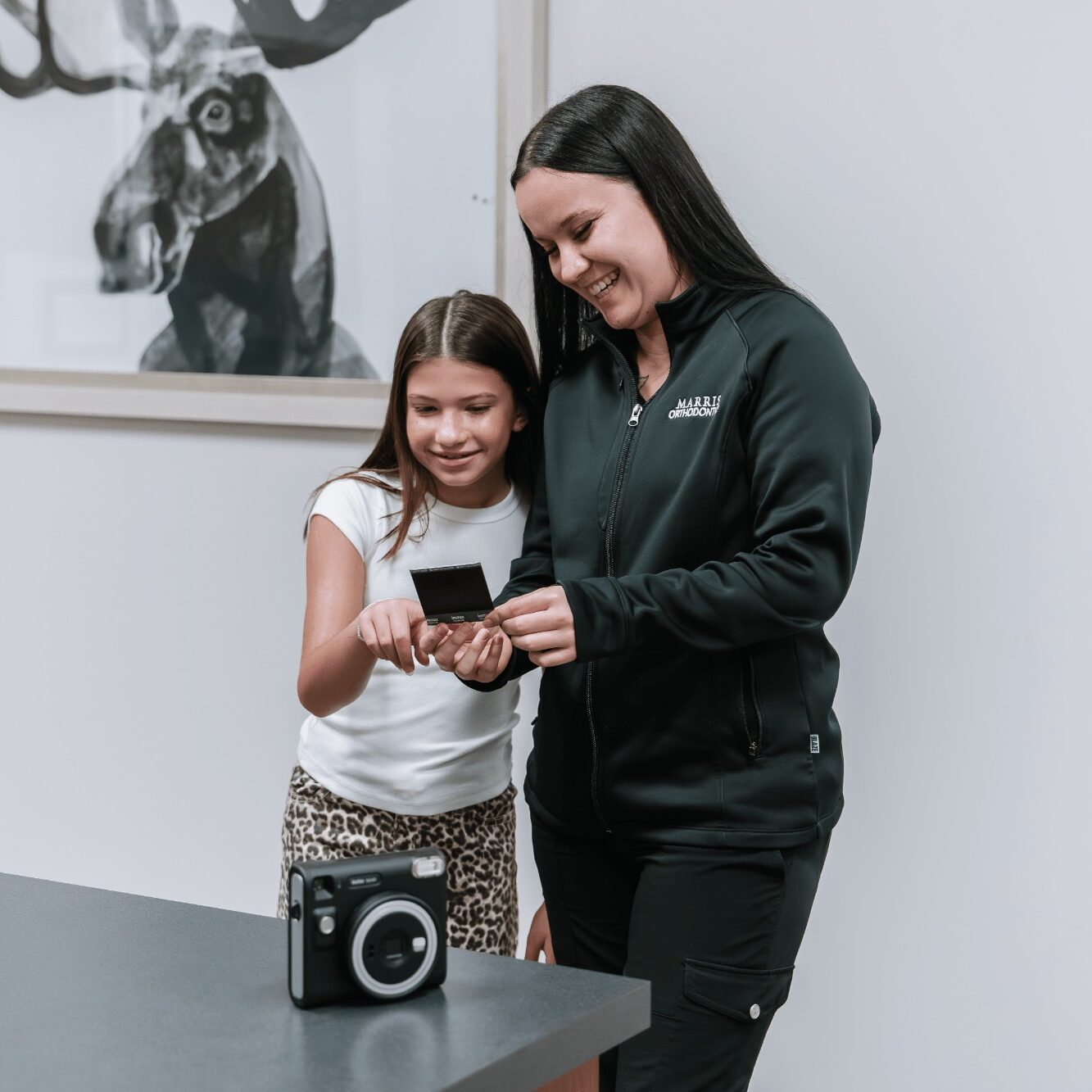 Child and orthodontist looking at a photo together, showcasing a friendly environment at Marris Orthodontics in Orlando, emphasizing fun and care in orthodontic treatment for children.